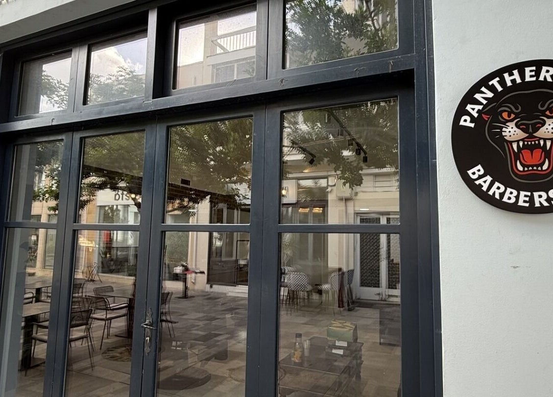 Front view of Panther Cuts barbershop in Pafos, Pafos, CY showcasing glass doors and logo.