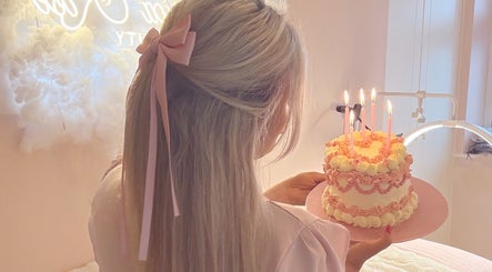 Woman with cake and candles at Jessica Rose Beauty, Leigh on Sea, GB, creating a serene atmosphere.