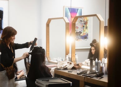 Stylist creating elegant hairstyle at Salome the Salon Stellenbosch, Western Cape, ZA in a modern, light-filled space.