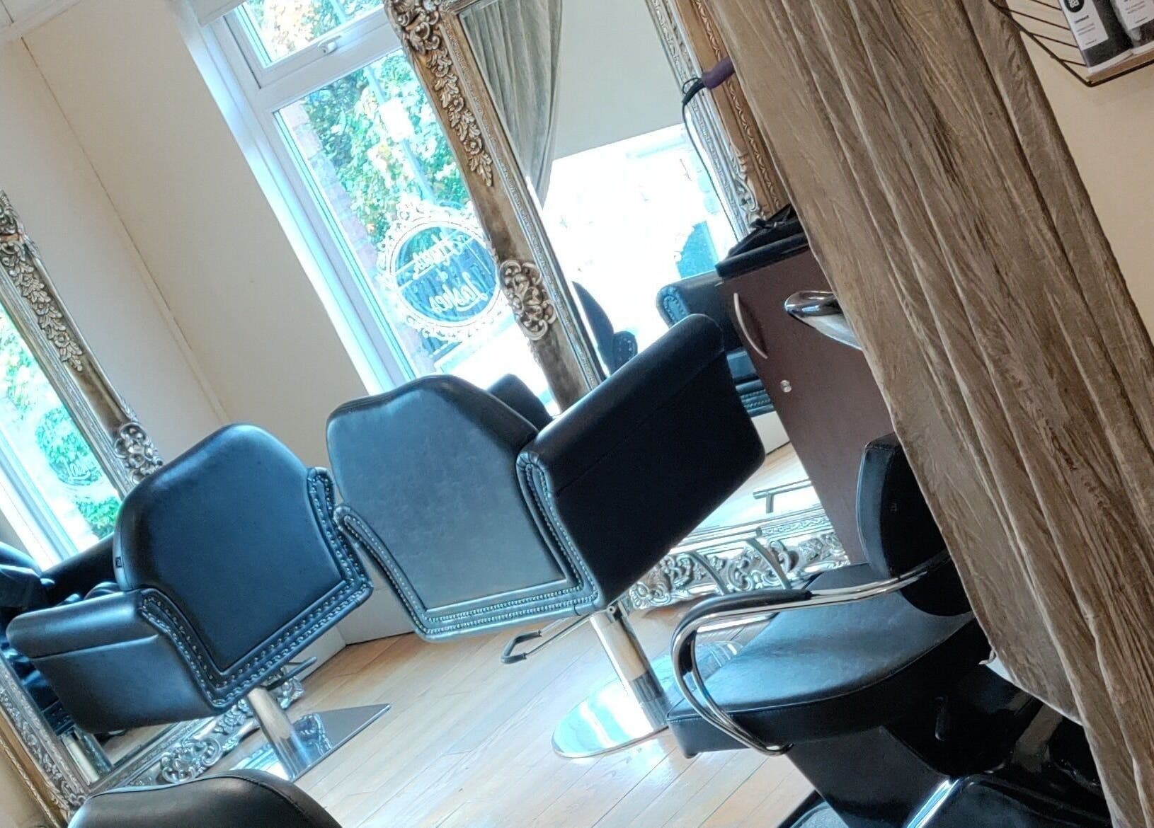 Interior of Claire Scott Professional Hairstylist in Ballyclare, Northern Ireland, showcasing chic salon chairs and mirrors.