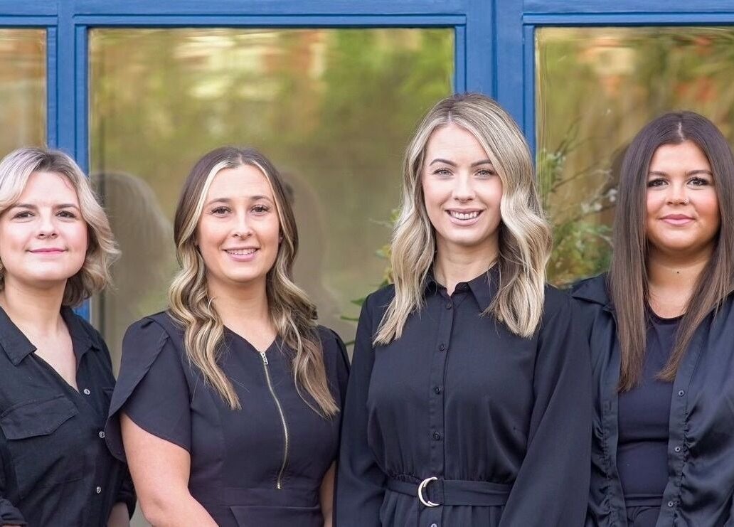 Four stylists from Kaleido Hair & Beauty in Whitwell, England, GB, pose confidently in front of the salon.