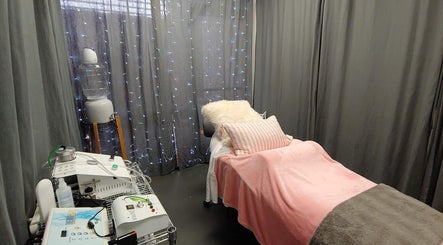 Cozy treatment room at Facelift Lounge with pink linens and equipment, Newport Beach, California, US.