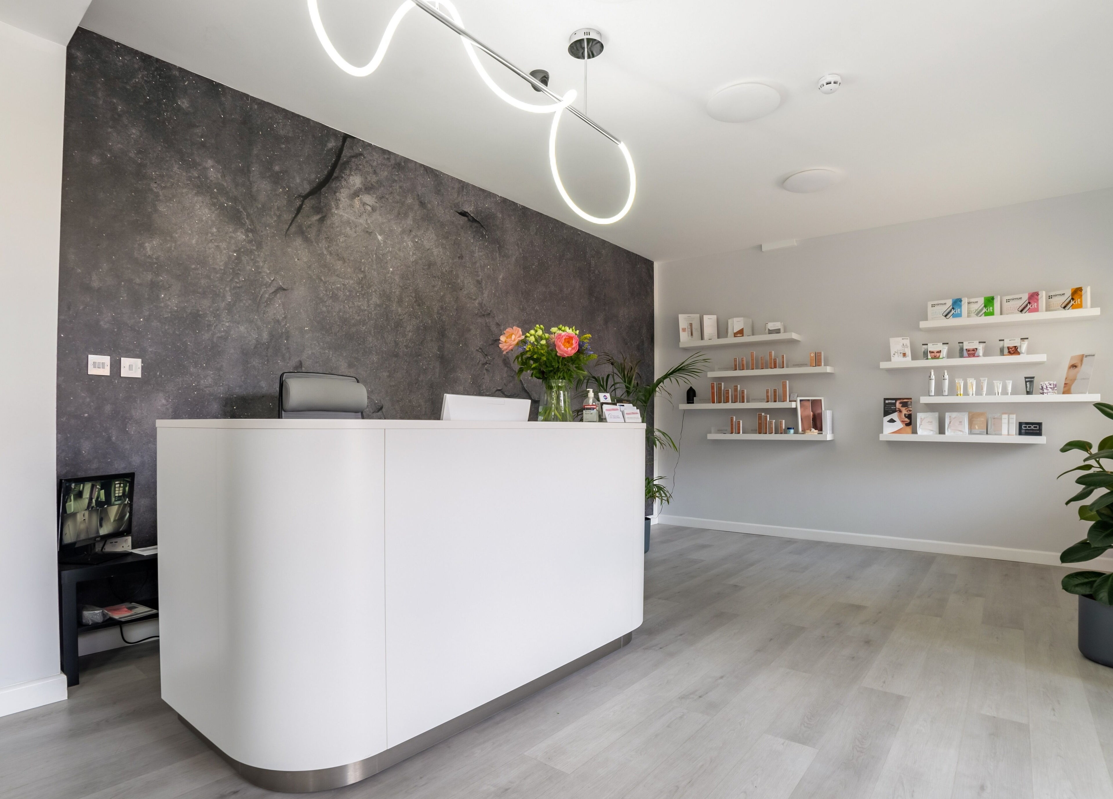 Modern reception at In-DERM Skin Clinic Chiswick in London, England, GB with elegant design and skincare products display.