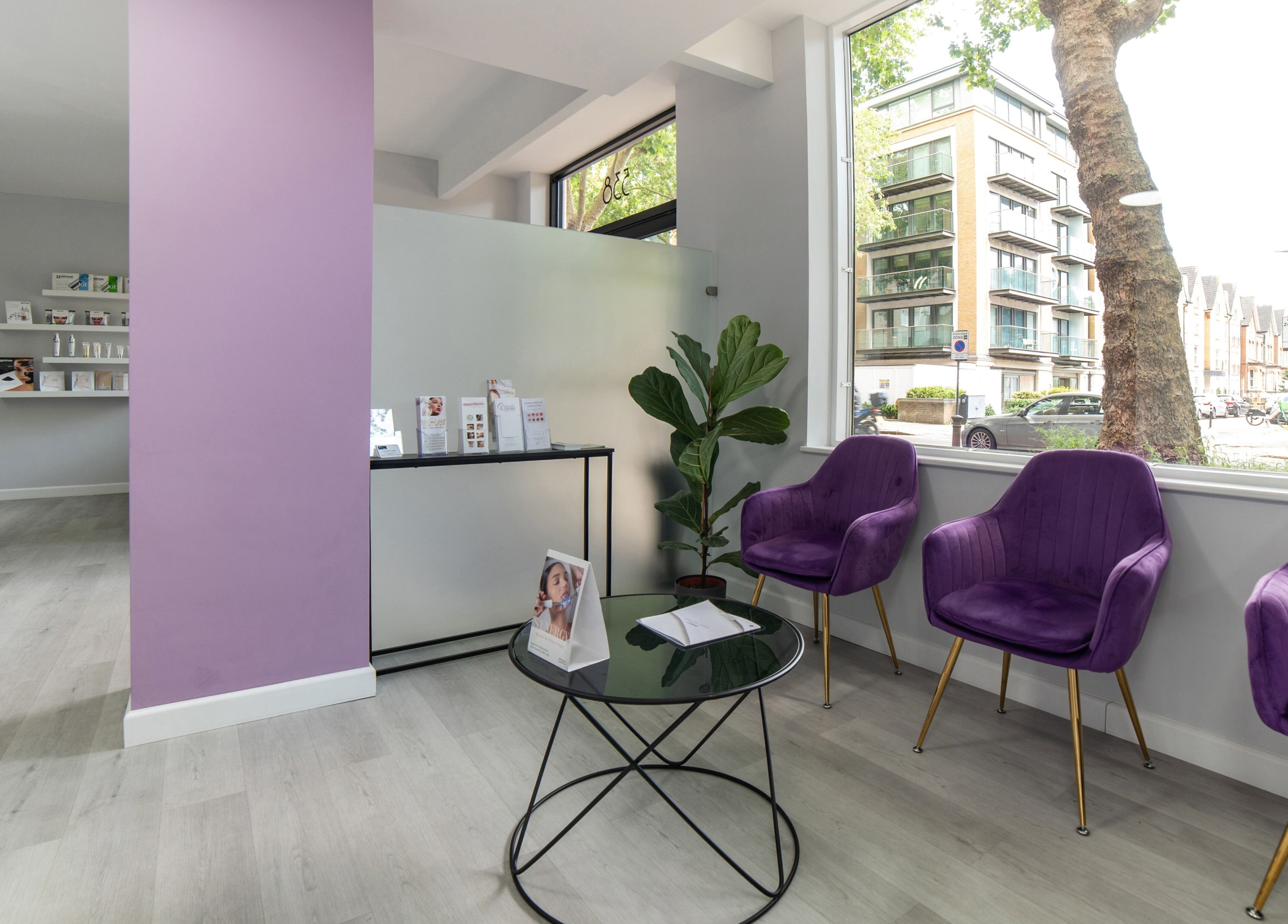 Inviting seating area in In-DERM Skin Clinic Chiswick, London, England, GB with purple chairs and modern decor.