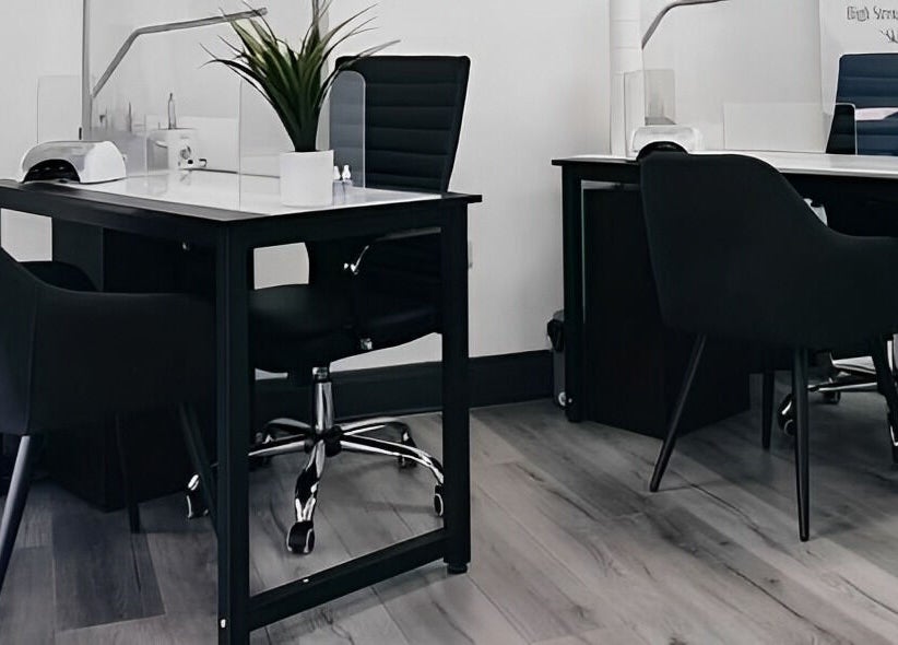 Modern nail treatment area at Pure Nails and Aesthetics, Newton Abbot, England, GB featuring sleek black chairs.