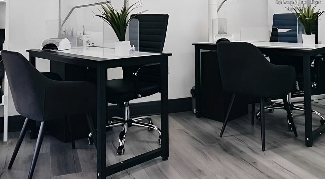 Modern nail treatment area at Pure Nails and Aesthetics, Newton Abbot, England, GB featuring sleek black chairs.