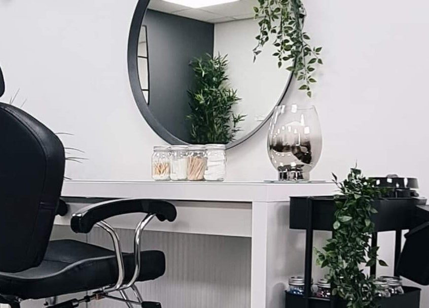 Elegant salon setup at Pure Nails and Aesthetics, Newton Abbot, England, GB with a round mirror and greenery.