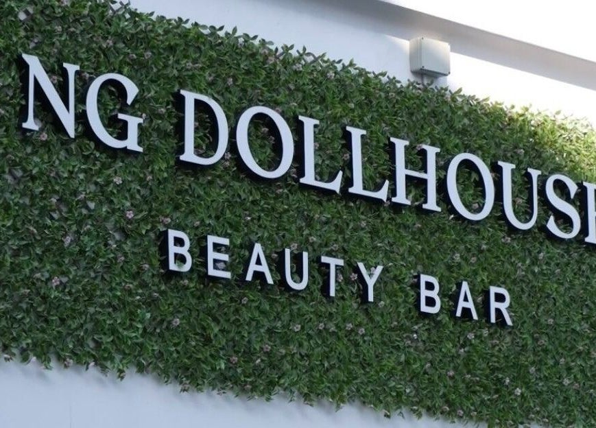 NG Dollhouse sign on a lush green wall in Germasogeia, Limassol, CY.