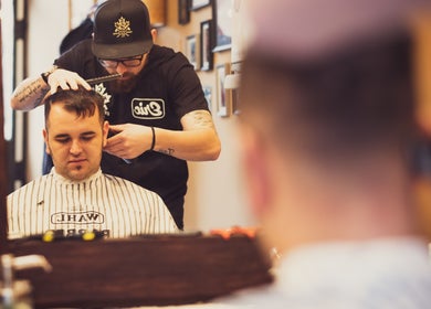 Barber styling a client's hair at The Canadian Barbershop in Praha, Hlavní město Praha, CZ.