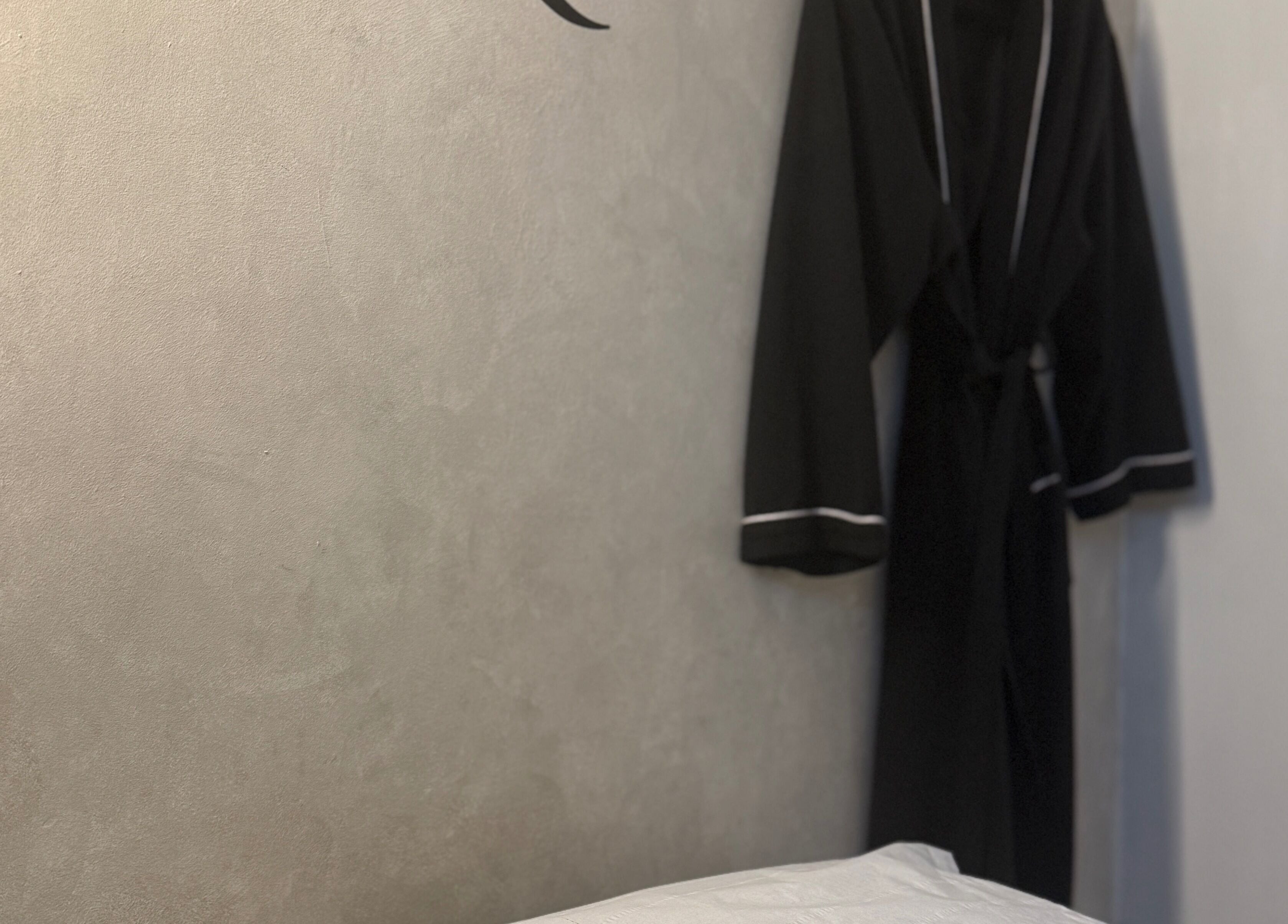 Relaxing treatment room at Body Revolution Aesthetics in Leeds, England, GB, featuring a robe on a wall.