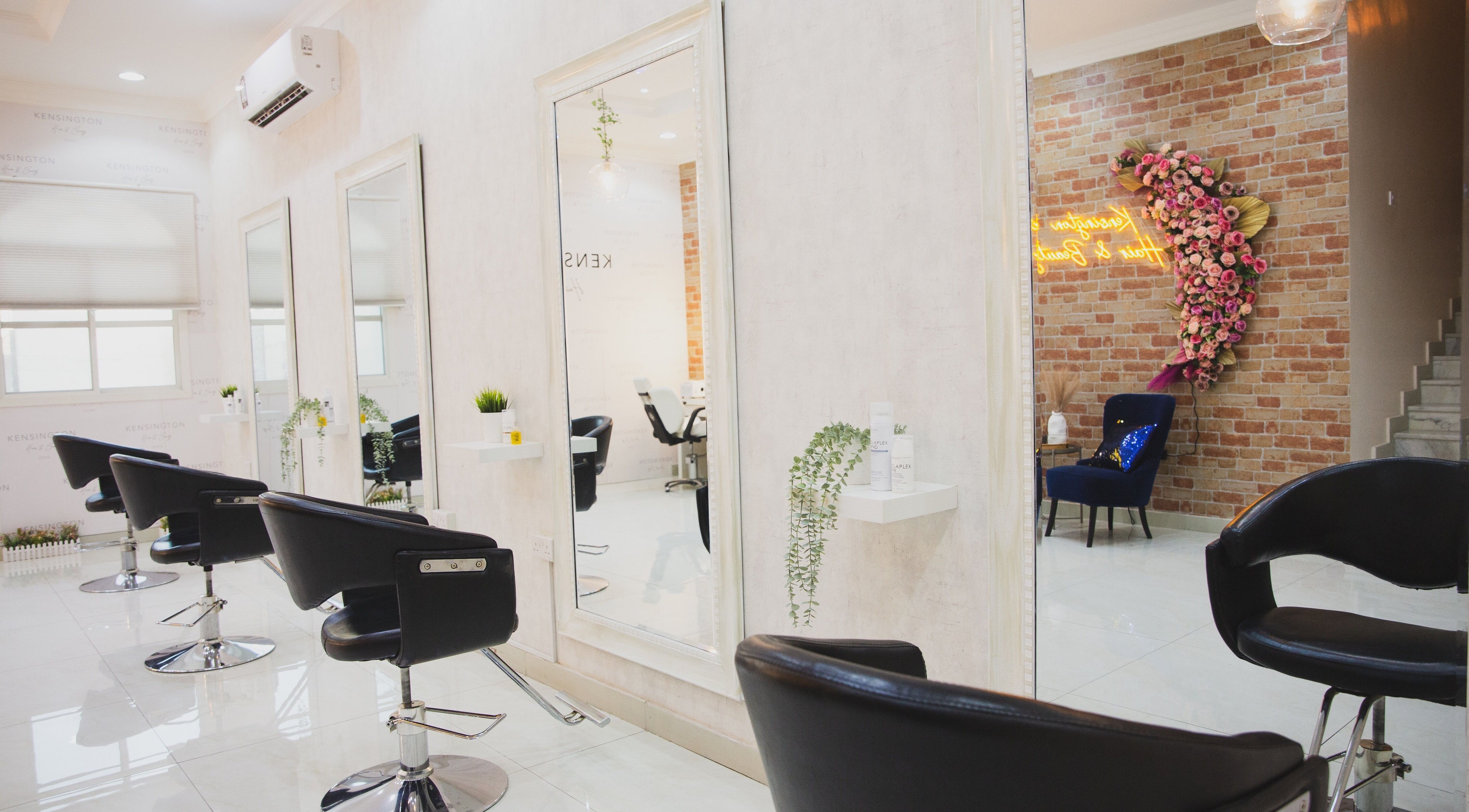 Interior of Kensington Hair & Beauty, Doha, Al Rayyan Municipality, QA with chic styling chairs and mirrors.