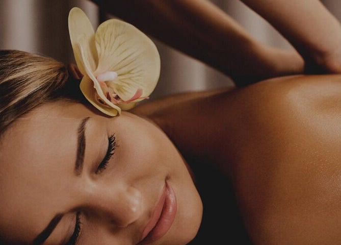 Relaxing massage at Hawaiian Hush Home Service - Dubai Only in Dubai, Dubai, AE with an orchid on woman's hair.