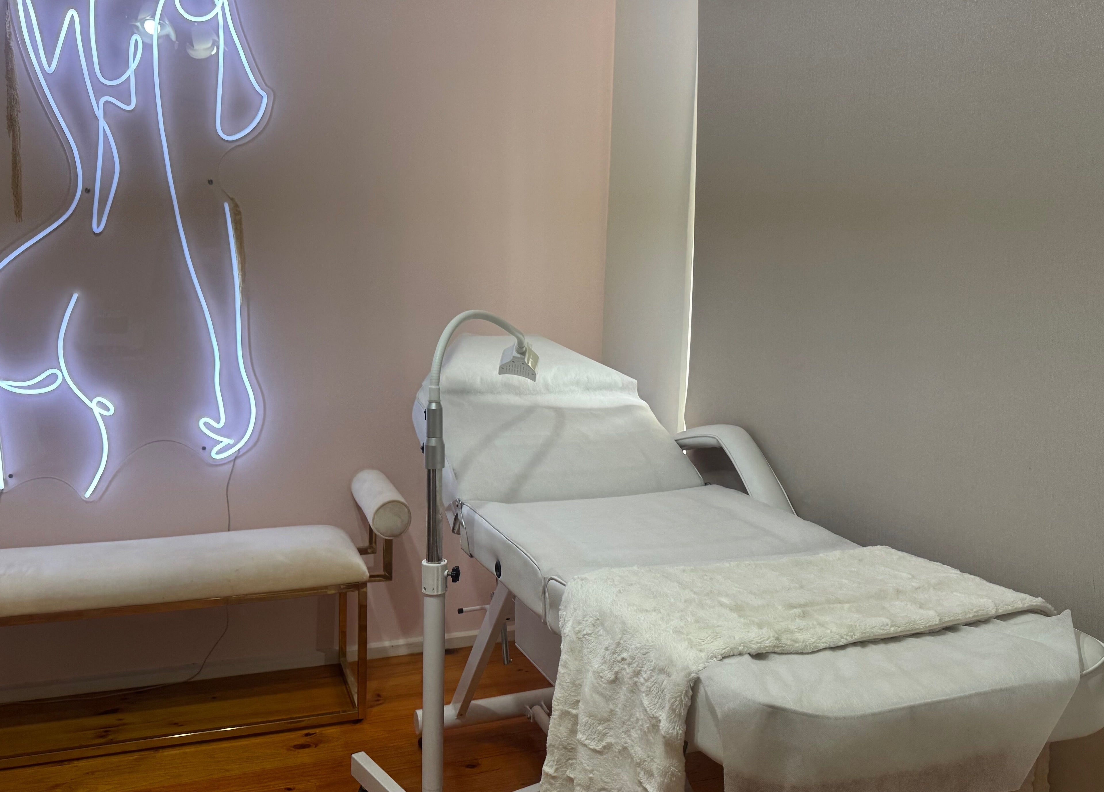 Calm therapy room at Luxe Contouring By Sofia, Melbourne, Victoria, AU with treatment bed and artistic neon decor.