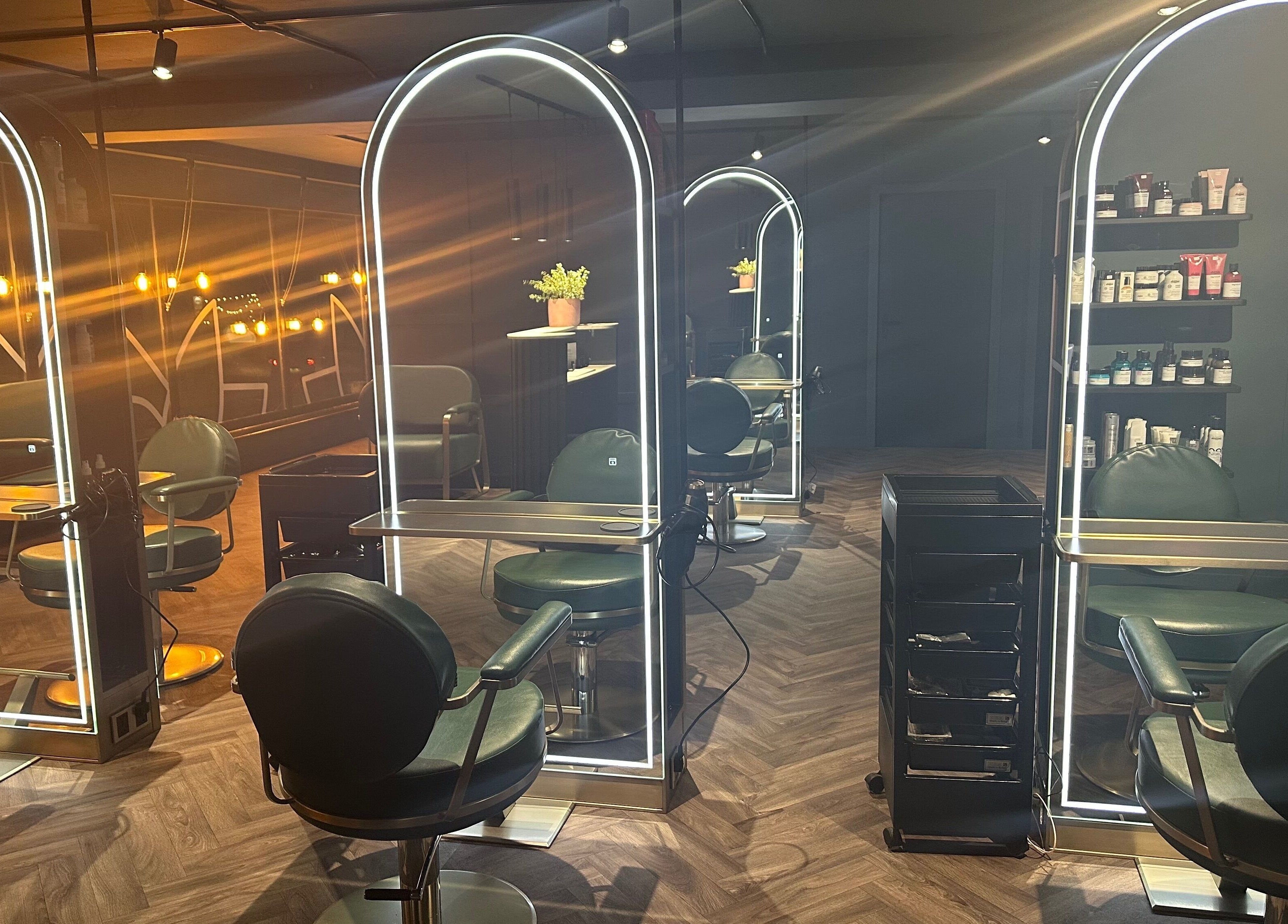 Luxury salon chairs and illuminated mirrors at Chandler and Co., Bedale, England, GB, creating a stylish ambiance.