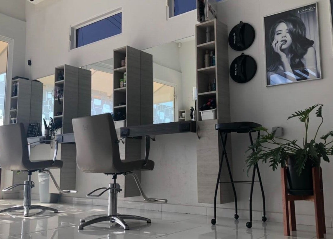 Modern salon interior at Mel An Gi Hair NV, Paramaribo, SR, featuring sleek chairs and stylish décor.