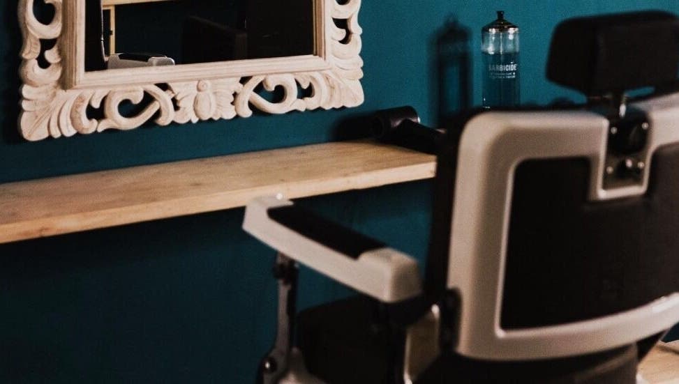 Interno di The BarBer a Martina Franca, Puglia, IT con sedia da barbiere e specchio decorativo.