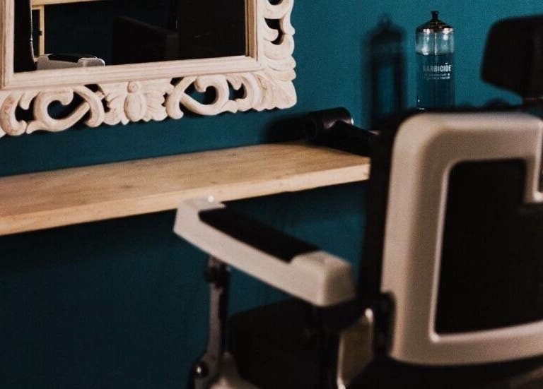 Interno di The BarBer a Martina Franca, Puglia, IT con sedia da barbiere e specchio decorativo.