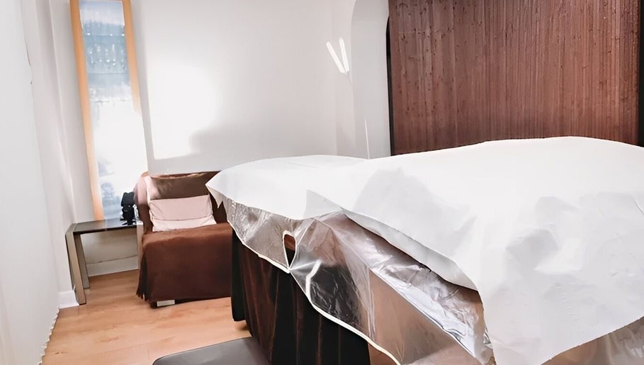 Relaxing treatment room at HRM Beauty, Rayleigh, England, GB, with cozy couch and massage table.