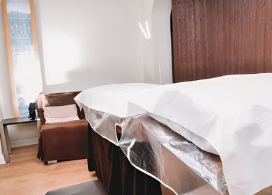 Relaxing treatment room at HRM Beauty, Rayleigh, England, GB, with cozy couch and massage table.