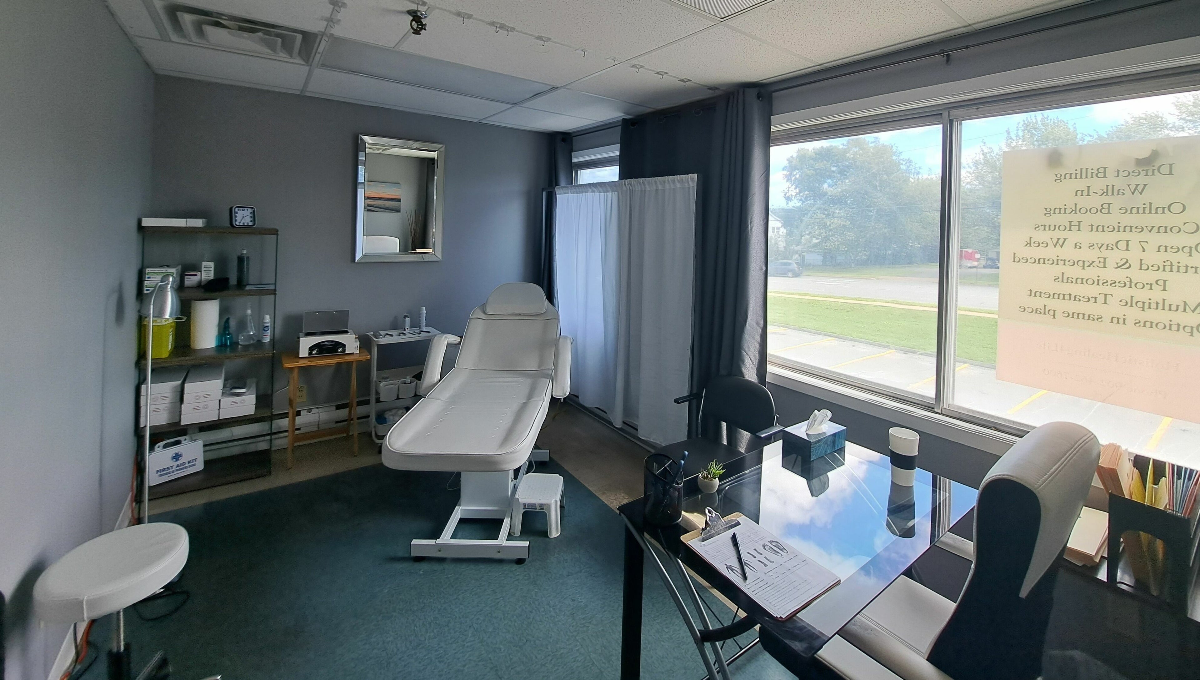 Treatment room at Holistic Healing 4 Life in Dartmouth, Nova Scotia, CA with a white therapy chair and large windows.