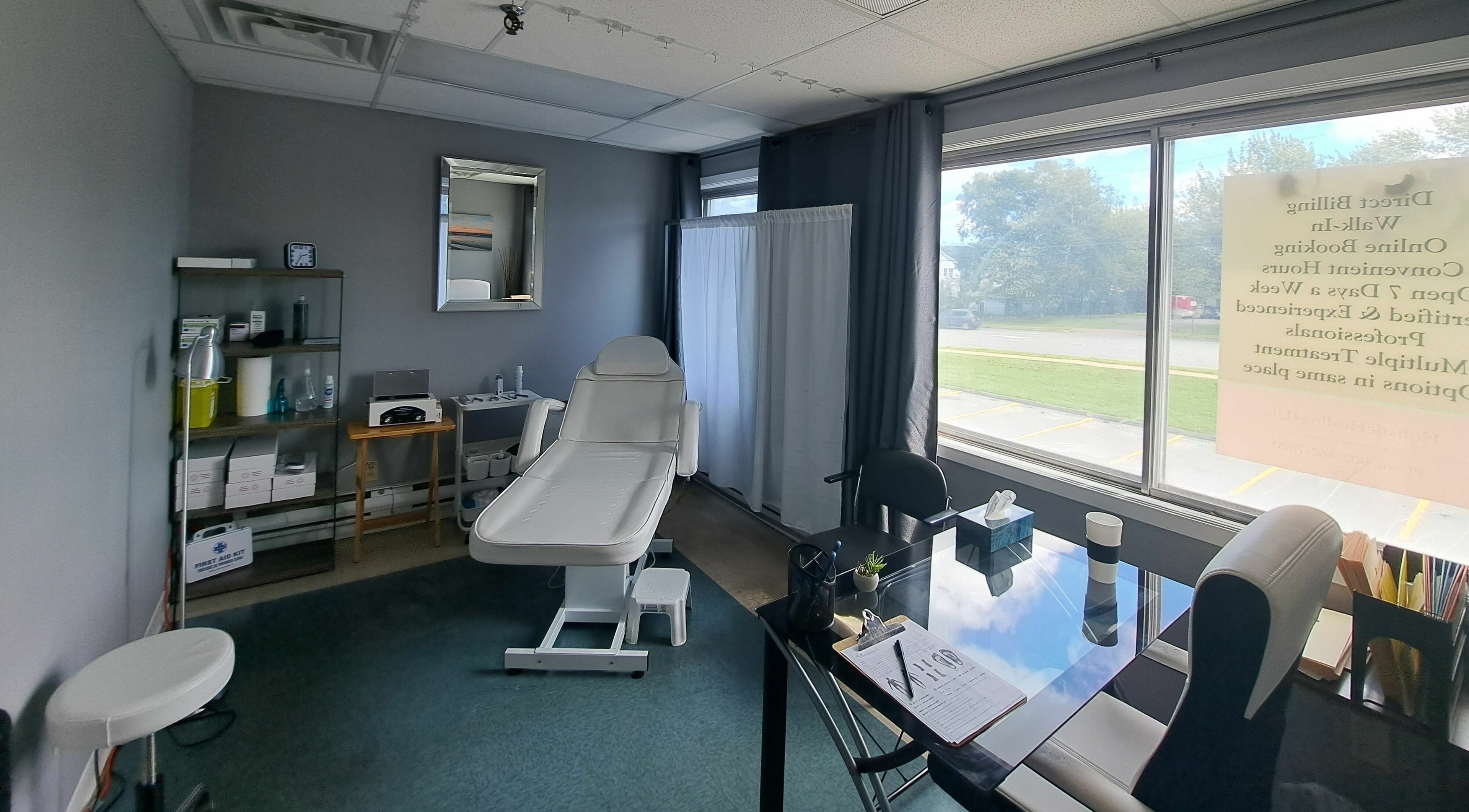 Treatment room at Holistic Healing 4 Life in Dartmouth, Nova Scotia, CA with a white therapy chair and large windows.