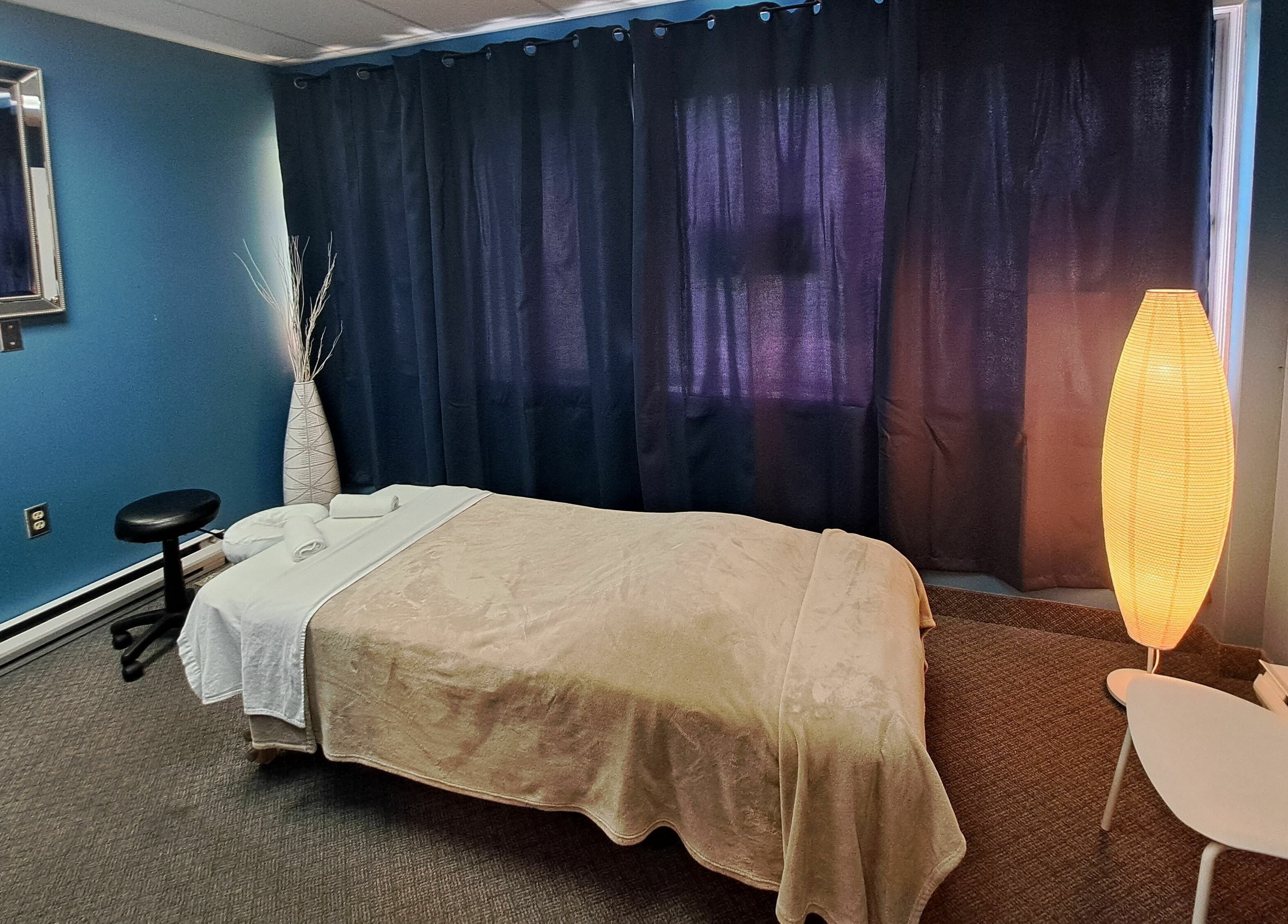 Tranquil massage room at Holistic Healing 4 Life, Dartmouth, Nova Scotia, CA with soft lighting and cozy decor.