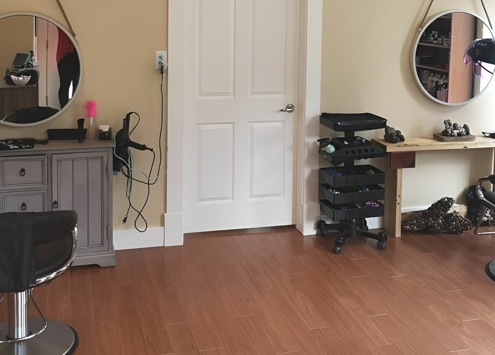 Inside Kat's Hair Studio in Sooke, BC, featuring a stylish chair, mirrors, and hair tools on a wooden floor.