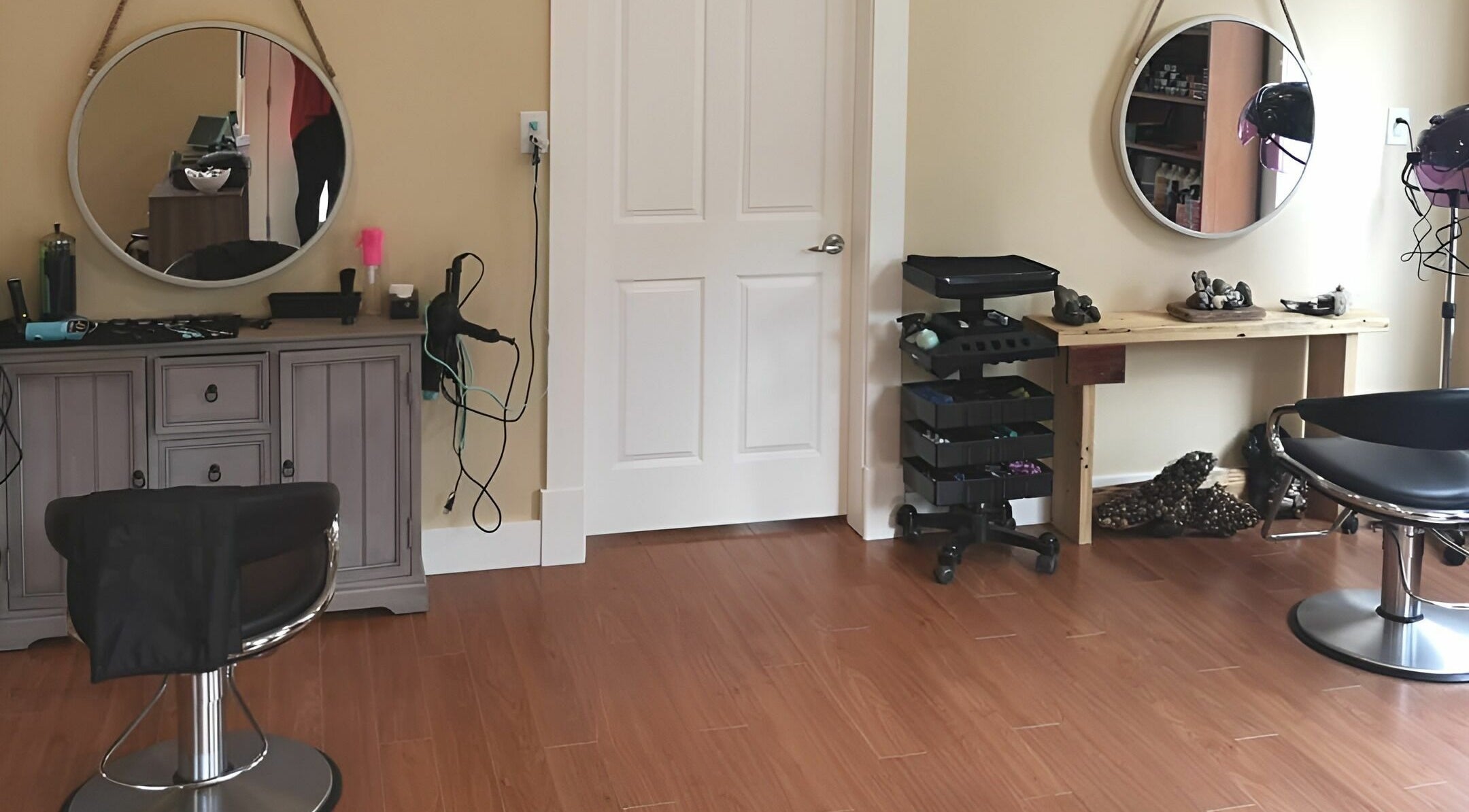 Inside Kat's Hair Studio in Sooke, BC, featuring a stylish chair, mirrors, and hair tools on a wooden floor.