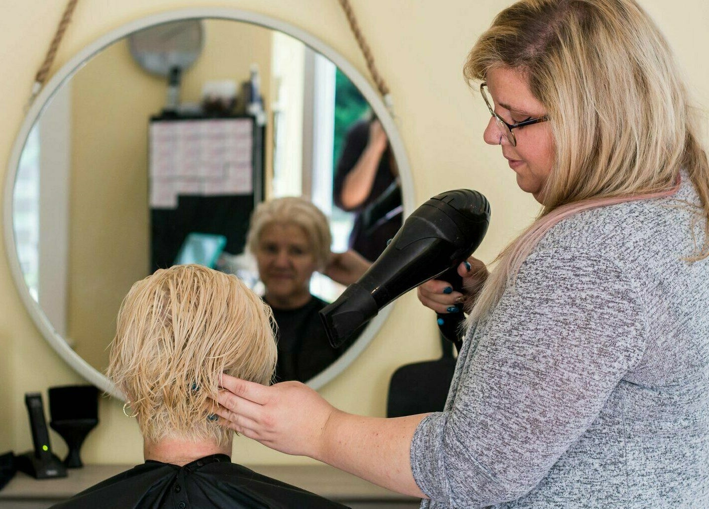 Stylist blow drying hair at Kat's Hair Studio, Sooke, British Columbia, CA. Professional hair care in action.