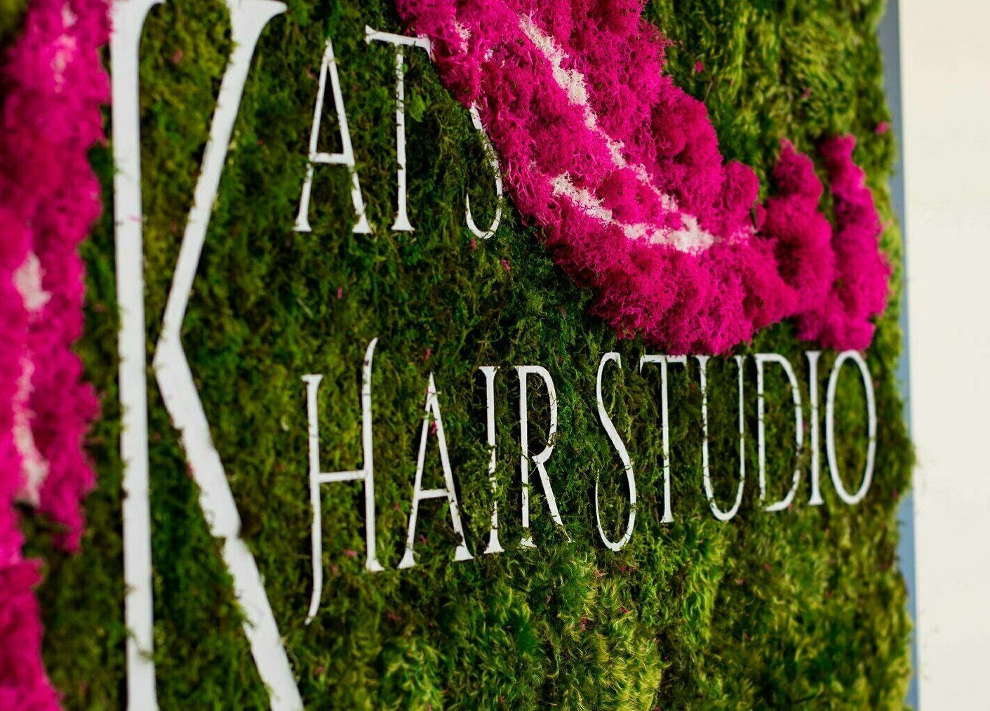 Kat's Hair Studio sign on vibrant moss backdrop in Sooke, British Columbia, CA.