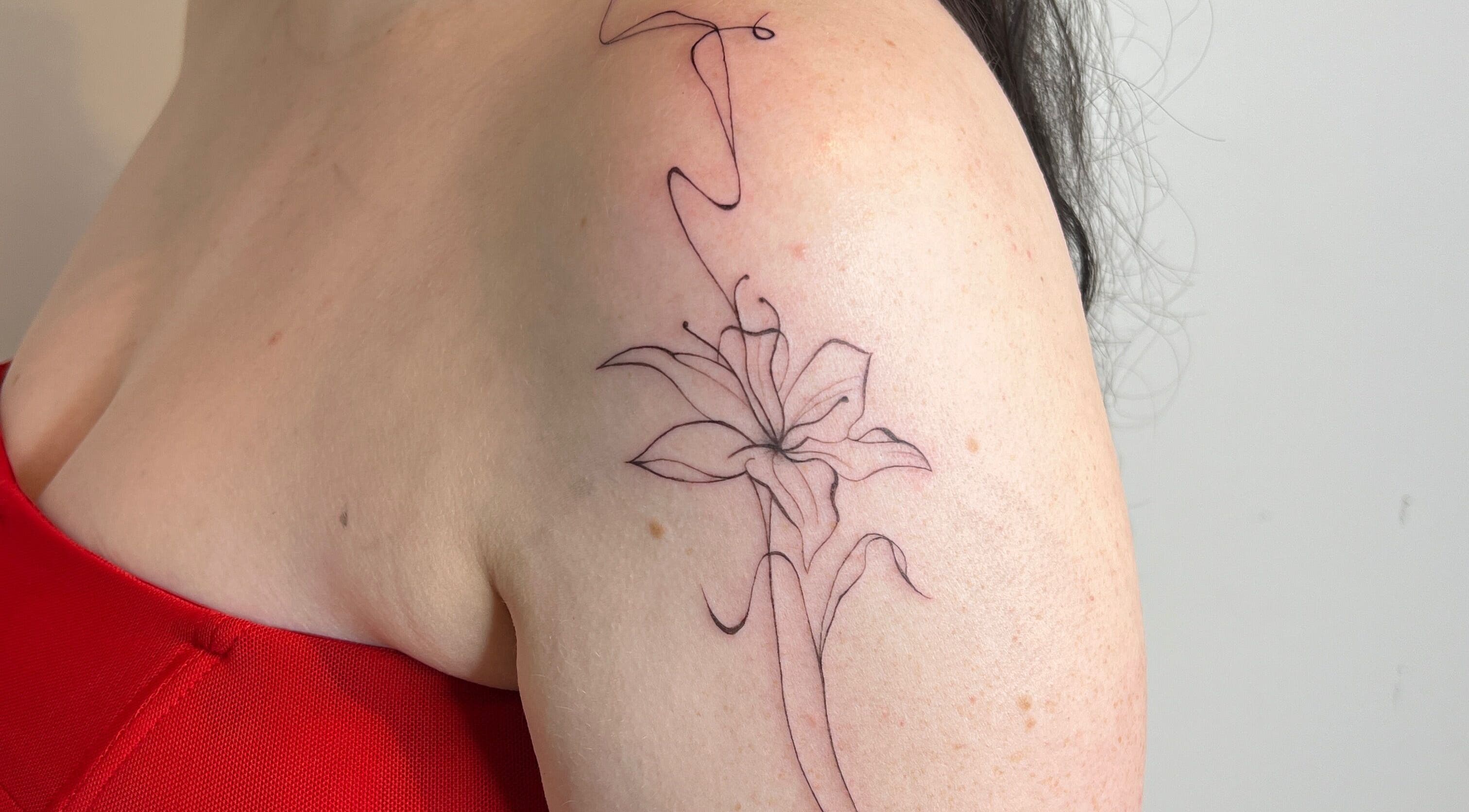 Delicate floral tattoo on shoulder at Inkd Aesthetics, Surfers Paradise, Queensland, AU.