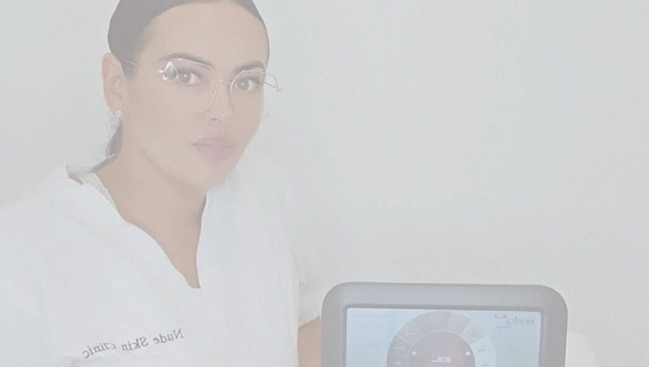 Professional at Nude Skin Clinic, Naomi, Manchester, England with advanced skin analysis device.