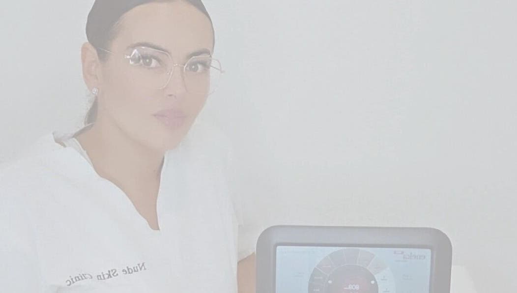 Professional at Nude Skin Clinic, Naomi, Manchester, England with advanced skin analysis device.