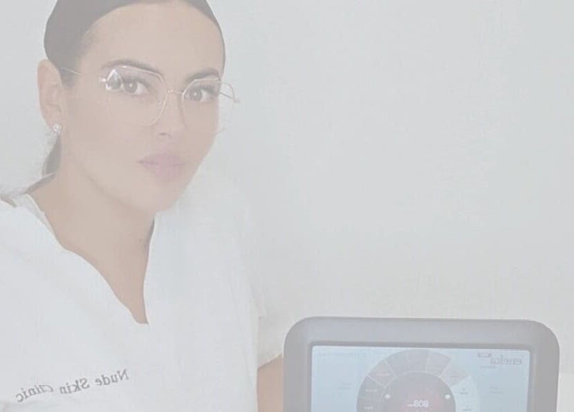 Professional at Nude Skin Clinic, Naomi, Manchester, England with advanced skin analysis device.