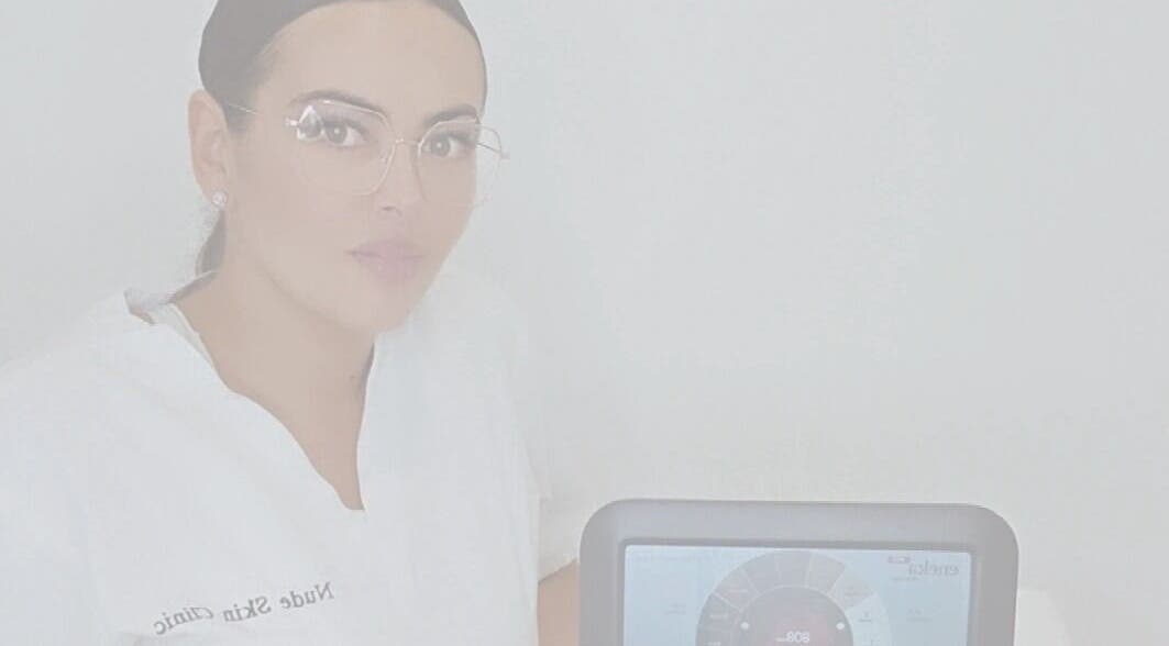 Professional at Nude Skin Clinic, Naomi, Manchester, England with advanced skin analysis device.