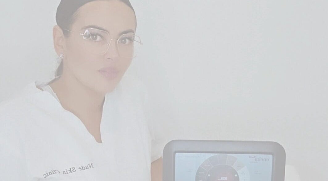 Professional at Nude Skin Clinic, Naomi, Manchester, England with advanced skin analysis device.