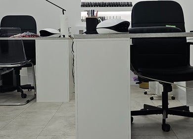 Modern nail station at Nude Skin Clinic (Naomi) in Manchester, England, GB, showcasing sleek chairs and tidy surfaces.