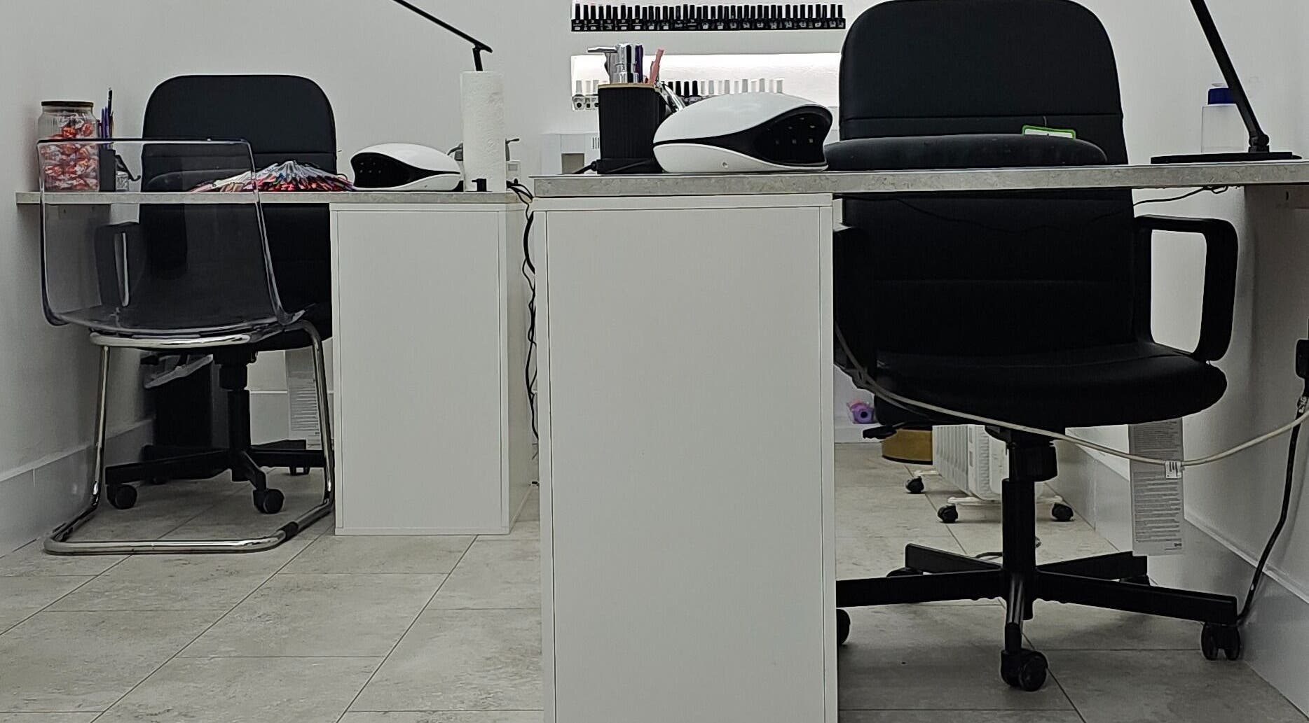Modern nail station at Nude Skin Clinic (Naomi) in Manchester, England, GB, showcasing sleek chairs and tidy surfaces.