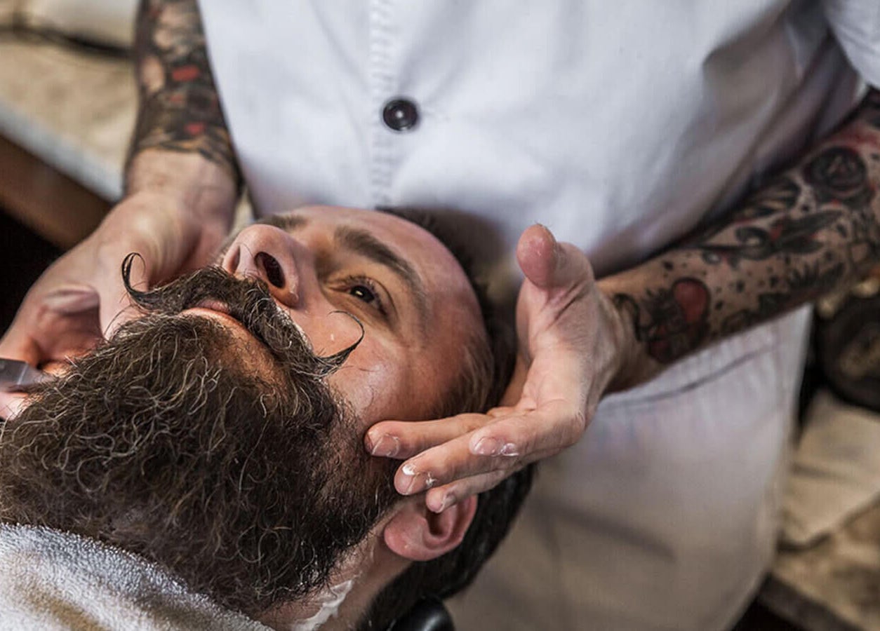 A barber at Modern Man South End shapes a beard in Charlotte, North Carolina, US with precision and care.