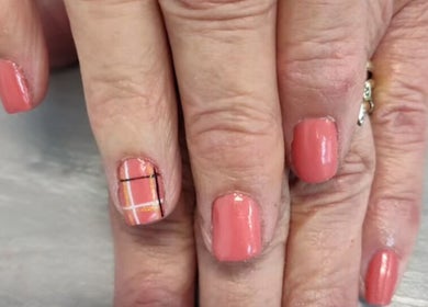 Elegant coral manicure with plaid accent nail at Pedi Lounge Nail Salon, Anderson, Indiana, US.
