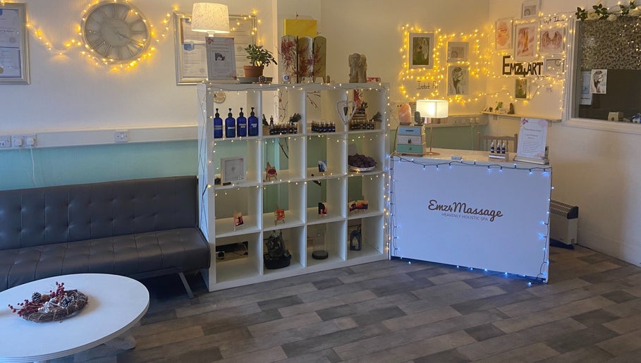 Welcome area of Emz4massage in Ilkeston, England, GB, featuring cozy seating and decorative shelves.
