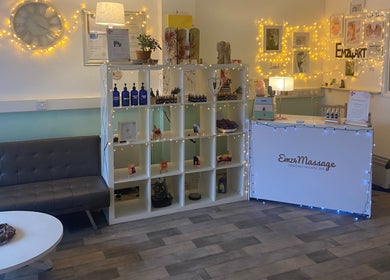 Welcome area of Emz4massage in Ilkeston, England, GB, featuring cozy seating and decorative shelves.