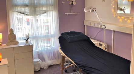 Calming massage room at Emz4massage, Ilkeston, England, GB with a bed and Buddha decor.