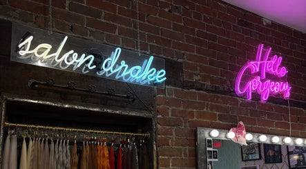 Enseignes au néon à Salon Drake, Montréal, Québec, CA, sur un mur de briques avec extensions de cheveux.