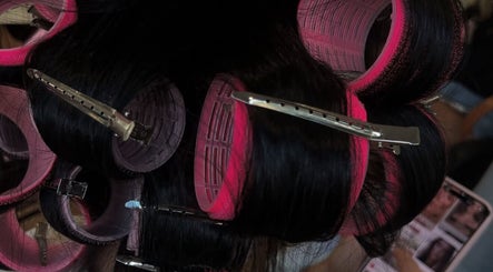 Gros plans de rouleaux rose sur cheveux noirs chez Salon Drake, Montréal, Québec, CA.