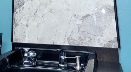 Luxurious washbasin at Haven Hair Salon in East Haven, Connecticut, US with marble backdrop.