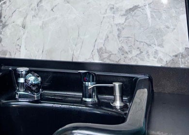Sleek wash station at Haven Hair Salon, East Haven, Connecticut, US, with modern faucet and marble backdrop.