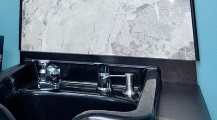 Sleek wash station at Haven Hair Salon, East Haven, Connecticut, US, with modern faucet and marble backdrop.