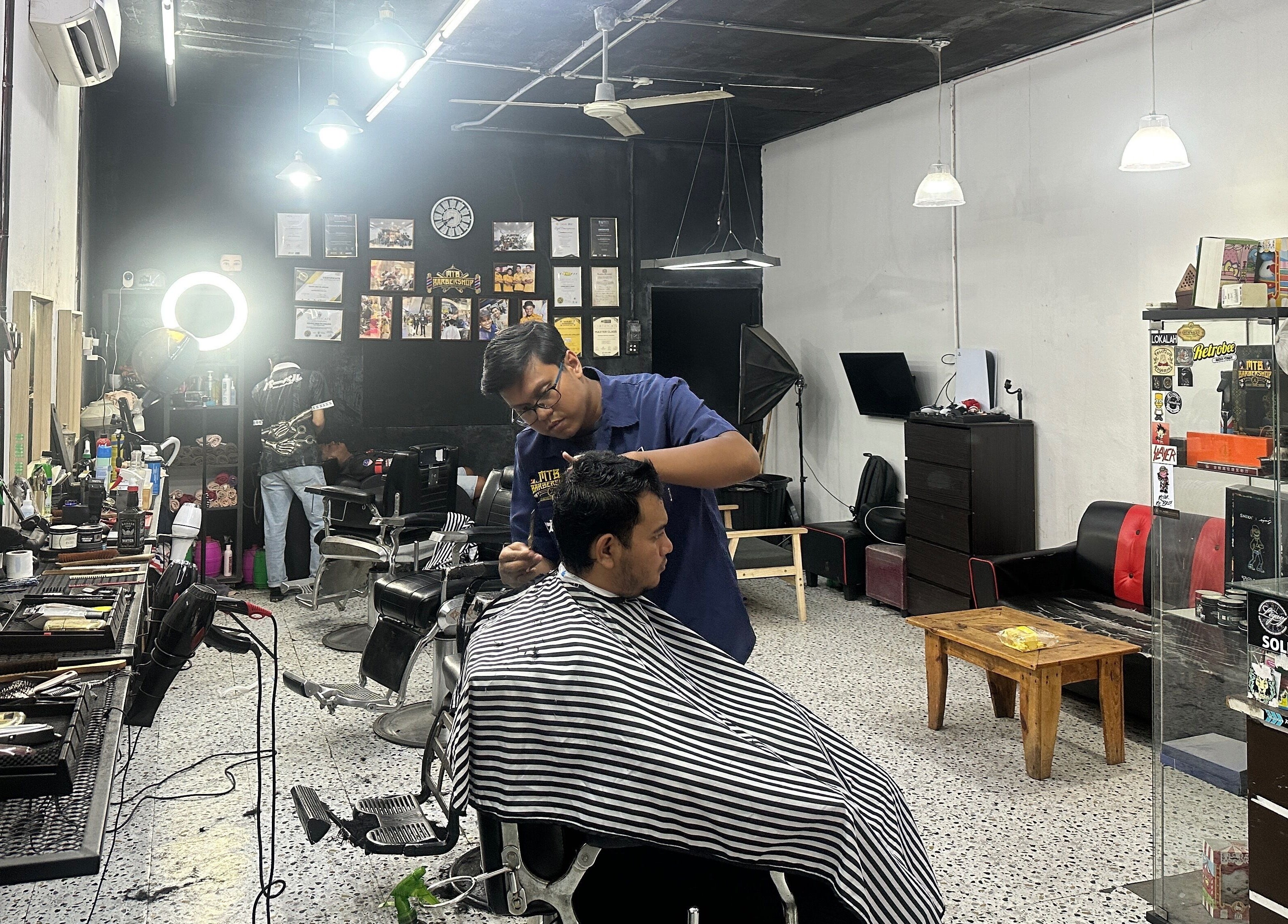 Barber styling hair at MTB Barbershop and Academy, Langkawi, Kedah, MY.
