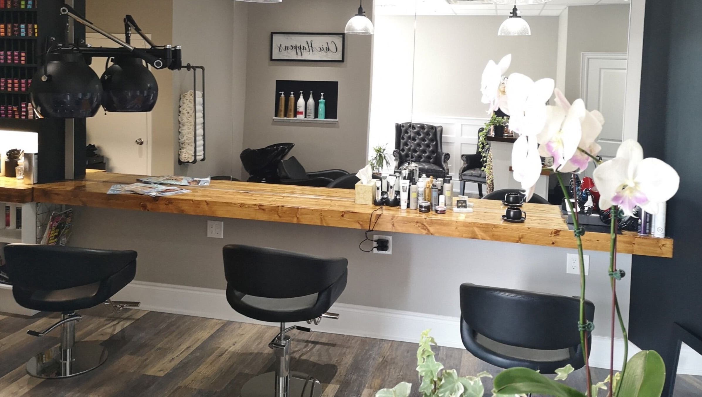 Modern salon interior at Hair Studio Midland in Midland, Ontario, CA with chic chairs and wooden styling counter.
